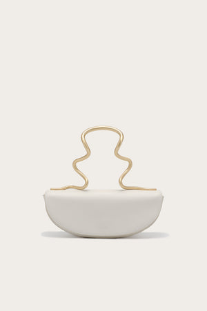 White handbag that features a gold-toned, wavy, sculptural top handle.