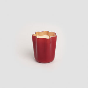 Red murano glass candle set on a gray backdrop.