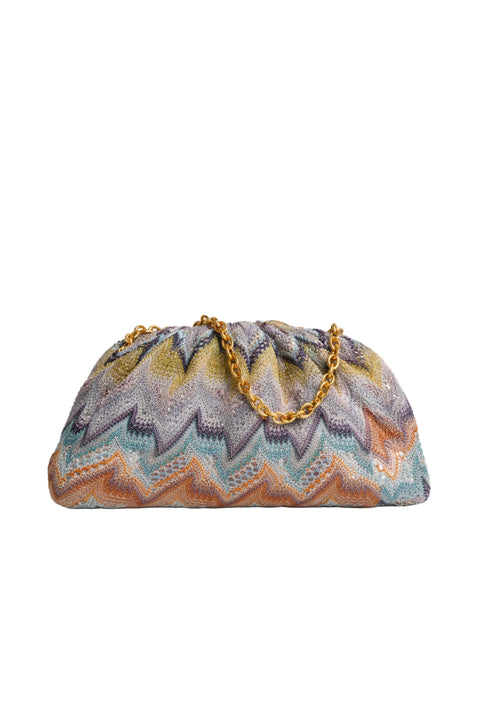 A Missoni mini clutch bag featuring the brand's signature chevron zigzag pattern in shades of blue, yellow, orange, and gray, with a gold-tone chain strap, shown on a white background.