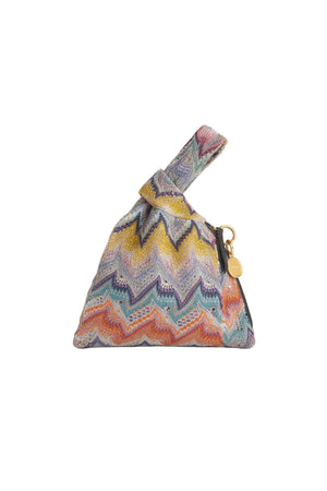 A small triangular zip pouch with a colorful zigzag chevron pattern in yellow, blue, purple, orange, and pink, featuring a top handle and a gold-tone charm, shown on a white background.