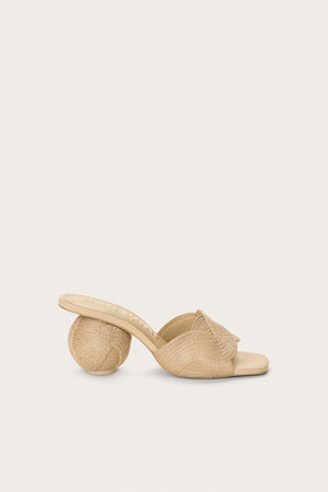 Side profile of a cream jute and leather mule that features a spherical heel and an open toe and back. 