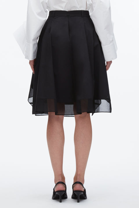 Back of woman wearing the black midi skirt with chiffon layer.