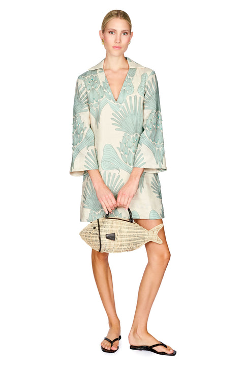 Woman wearing a light green and white patterned tunic dress on a white background 