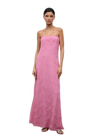 A woman wearing a strapless pink maxi dress with beaded embellishments