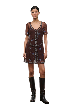 Woman wearing a brown sheer mini dress with embellishments on a white background