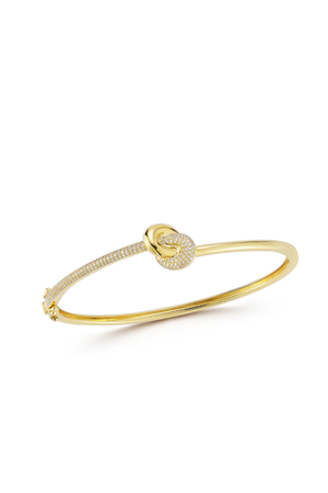 Gold bangle bracelet with a knot design and pave diamonds on a white background