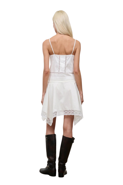 A woman wearing a white lace midi skirt with a matching white sleeveless top back angle