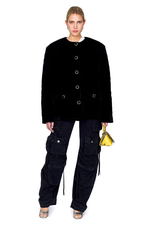 Centered stance of quilted velvet evening jacket with gold buttons and cargo pants
