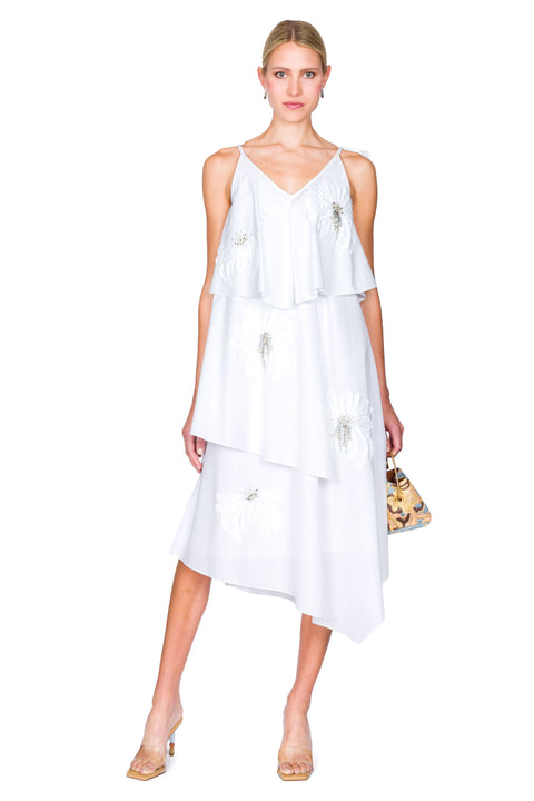 Woman wearing a white dress with a small multicolored handbag