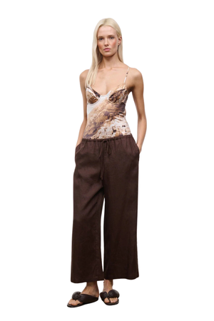 Woman wearing brown wide-leg pants on a white background