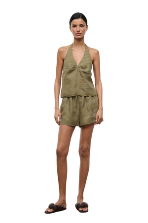 Woman wearing a green striped two-piece shorts set on a white background